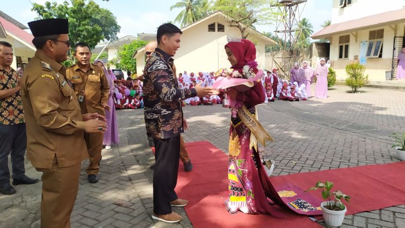 Wakil Pimpinan Perguruan Islam BM Muda Nurul Ilmi Padangsidimpuan Syahlan Ginting SE, memberikan buket bunga kepada Aisyahlim Fadillah Siregar yang berhasil meraih jura Putri Batik Cilik Indonesia 2023, ( 6/11).Waspada/Mohot Lubis