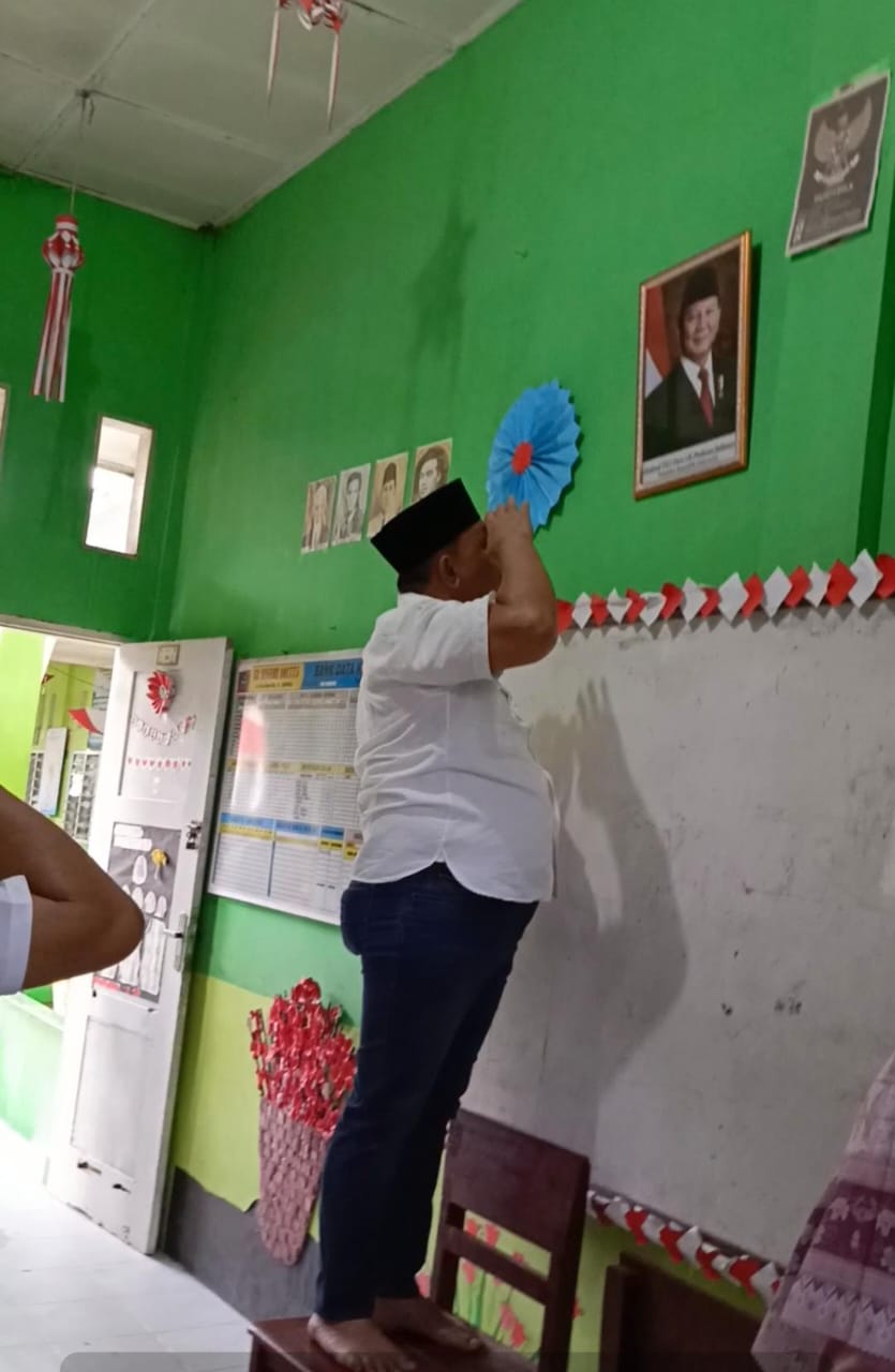 M.Dahnil Ginting Bantu Foto Presiden Dan Ratusan Botol Minuman Susu Gratis Di SD Negeri Sampali