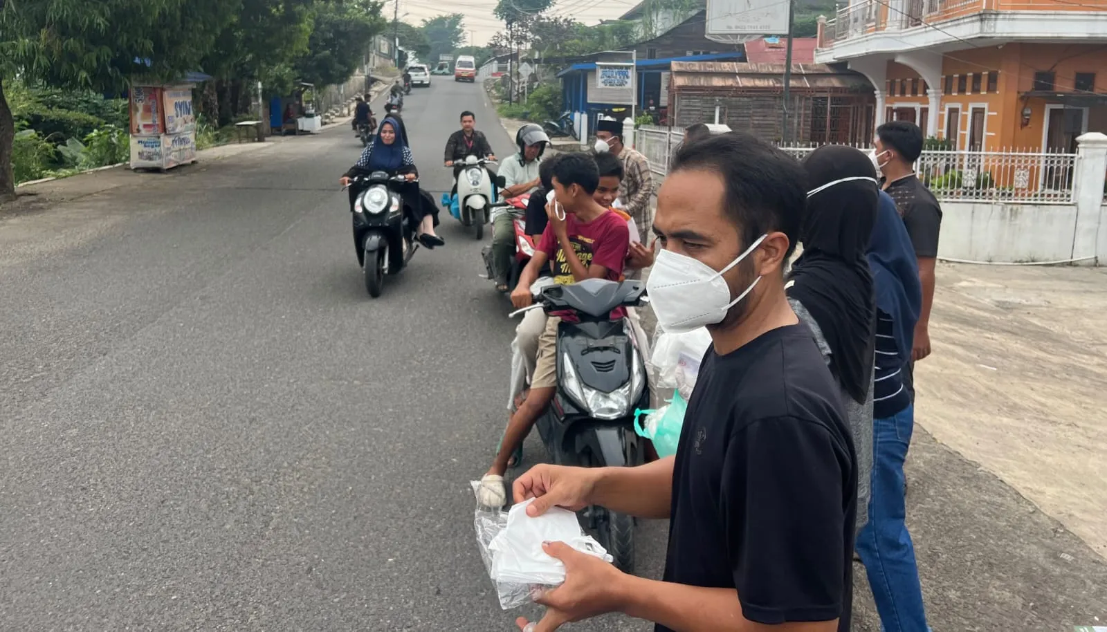 Peduli Kabut Asap, Rumah Sehat dan Warkop NHH Bagikan Masker dan Nasi Berkah kepada Pengendara