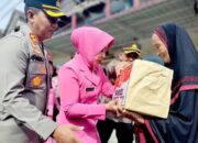 Ketua Bhayangkari Cabang Pidie Ny. Yayuk Padli. didampingi Kapolres Pidie AKBP Padli, dan Waka Polres Kompol Muhammad Taufiq menyerahkan paket Sembako kepada salah satu warga kurang mampu di Kota Sigli, Selasa (25/10). Waspada.id/Muhammad Riza