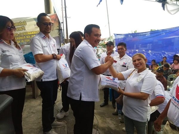 Ketua DPC Perindo Sunggal Bornok Simanjuntak saat membagikan beras kepada kader. (Waspada/Edward Limbong).