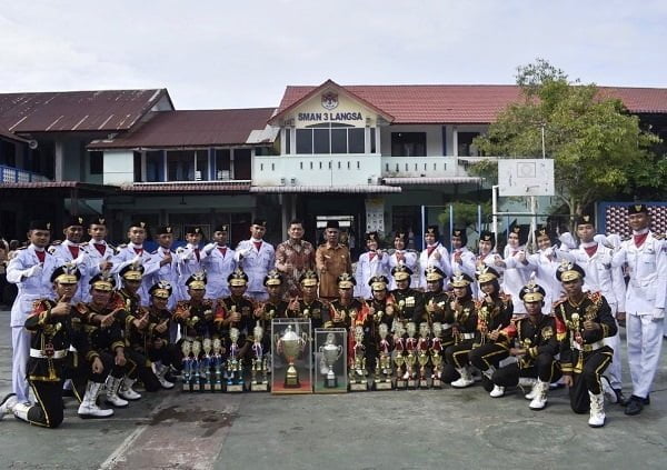 Anggota DPR RI Dapil Aceh II dari Fraksi Golkar, H. Ilham Pangestu didampingi Kepala SMA Negeri 3 Langsa, Rusli S.Ag foto bersama dengan Tim Pakibraka Juara Umum KIPAS 10 se Sumatera Utara, Senin (17/10). Waspada/dede