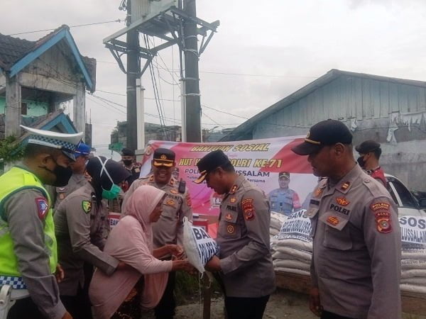 KAPOLRES Subulussalam, Muhammad Yanis, SIK, MH saat menyerahkan bansos berupa beras kepada warga, Waspada.id/Khairul Boangmanalu
