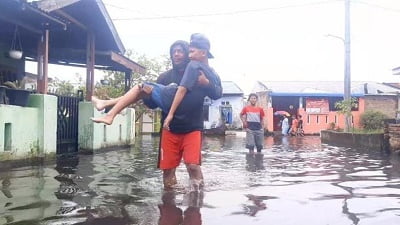SEORANG warga menggotong anaknya yang menderita sakit kulit menuju Posko Kesehatan untuk mendapatkan pemeriksaan kesehatan pasca banjir yang merendam ribuan rumah di Kelurahan Sei Mati Kecamatan Medan Labuhan, Kamis (27/10).