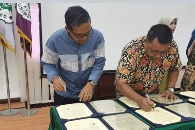 KEPALA SMAN 2 Medan, Drs Buang Agus,(kiri) saat penandatanganan Surat Perjanjian Kerjasama (SPK) di Unimed. Waspada/ist