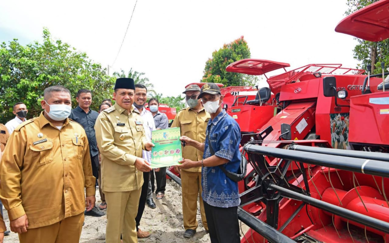 BUPATI Batubara Ir.H.Zahir, M.AP pada penyerahan alat mesin pertanian (Alsintan) berupa combine havester atau alat panen padi bantuan aspirasi dari Anggota Komisi IV DPR RI Djarot Saiful Hidayat. Waspada,id/Iwan Has