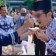 KETUA OSIS SMA Negeri 3 Medan D,afa Abiyyu (kiri) menyulangkan nasi tumpeng kepada Kepala Sekolah Mukhlis S.Pd, M.Si, usai Peringatan Hari Guru Nasional di lapangan sekolah tersebut, Jumat (25/11/2022). Waspada/ist