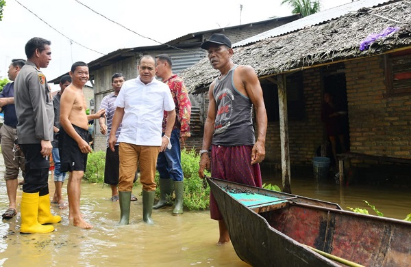 BUPATI Batubara, Ir. H. Zahir, M.AP bersama Kapolres serta sejumlah pejabat terkait menangani banjir sekaligus memastikan kondisi warga sambil menyalurkan bantuan bahan makanan maupun menyelusuri titik luapan banjir di Desa Simpanggambus, Limapuluh.Waspada/Iwan Has