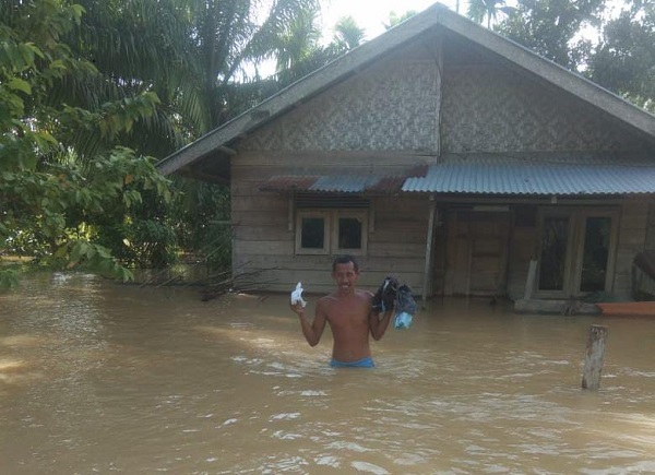 TERJEBAK BANJIR: Warga yang terjebak banjir mencoba menyelamatkan diri di Rantau Selamat, Kabupaten Aceh Timur, Selasa (8/11). Waspada/M Ishak