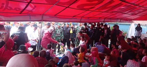 Mensos RI, Tri Rismaharini saat membagikan bingkisan untuk anak-anak korban banjir di posko pengungsian halaman Kantor Camat Bendahara,KabupatenAceh Tamiang. Waspada/Ist