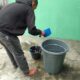 Seorang pelanggan PDAM Tirtasari Binjai memanfaatkan stok air dari tetangga dan isi ulang. (Waspada/Ria Hamdani)