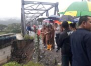 Pj Bupati Syakir dan Sekda, Mhd Ridwan beserta rombongan tinjau jembatan rangka baja di Desa Mamas yang amblas digerus banjir. Waspada/Seh Muhammad Amin