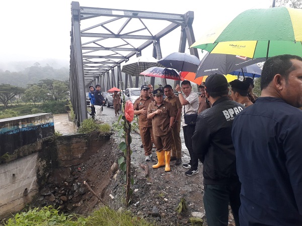Pj Bupati Syakir dan Sekda, Mhd Ridwan beserta rombongan tinjau jembatan rangka baja di Desa Mamas yang amblas digerus banjir. Waspada/Seh Muhammad Amin