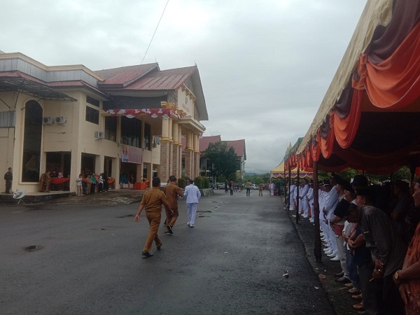 SALAH seorang Kepala Kampong yang akan dilantik memasuki lokasi acara saat acara sudah dimulai. Waspada/Khairul Boangmanalu
