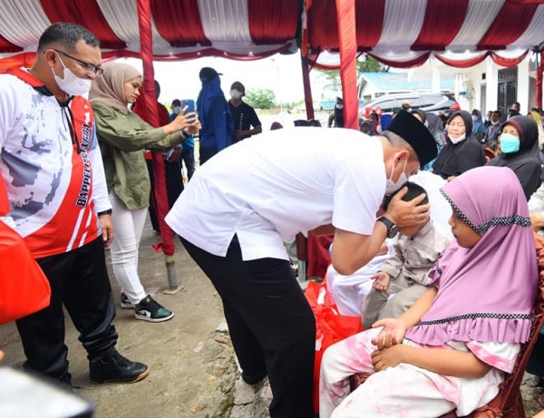 BUPATI Batubara Ir. H. Zahir, M.AP., bersama Ketua TP - PKK, Ny. Hj. Maya Indriasari Zahir dan Kepala Bappelitbangda, H. Abdu Zahrul bagikan paket sembako kepada anak yatim dan kaum duafha. Waspada/Iwan Has