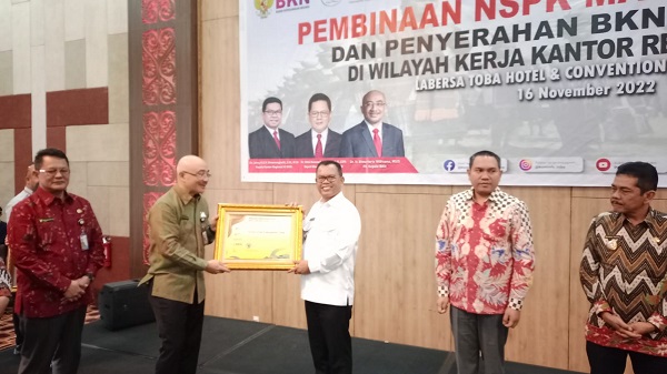 Bupati Toba, Poltak Sitorus menerima penghargaan BKN Award dari Kepala BKN Dr. Ir. Bima Haria Wibisana, M.Sis di Labersa Hotel Ballroom Balige, Rabu (16/11). Waspada/Ramsiana Gultom
