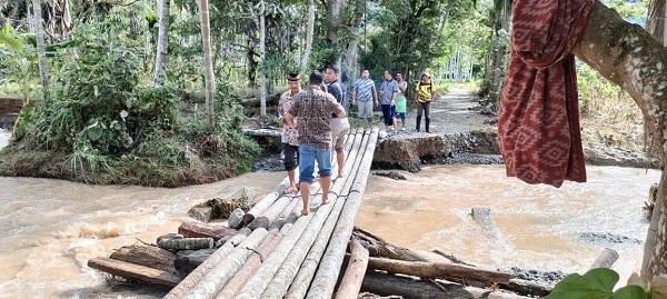 Warga terpaksa membuat titi darurat akibat anak sungai kecil berubah menjadi aliran sungai paska meluapnya sungai Lawe Kingan di Desa Buah Pala Kecamatan Lawe Sumur. Waspada/Ali Amran