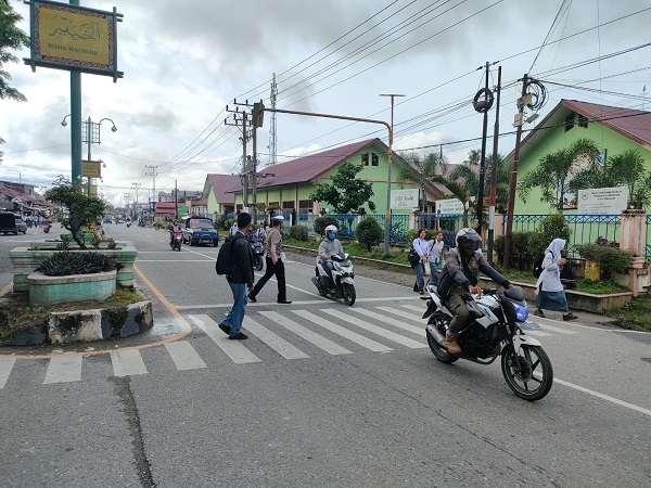 Daerah rawan macat Lalin, Satlantas Polres Agara bantu seberangi anak sekolah. Waspada/Seh Muhammad Amin