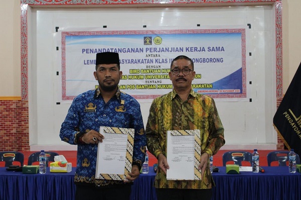 Kepala Lapas Siborong-borong Kelas IIB KemenKumham Sumatera Utara, Parlindungan Sirega, A.Md.IP, SH dan Biro Bantuan Hukum USI, Dr Sarles Gultom, SH, MH perlihatkan MoU tentang penyuluhan dan bantuan hukum bagi warga binaan setelah ditandatangani, di Kantor Lapas Siborong-borong, Selasa (29/11). Waspada.Id/ist