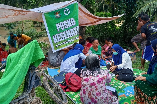 Petugas medis dari Puskesmas Tinggi Raja sedang memeriksa kesehatan masyarakat yang terdampak banjir. Waspada.id/Ist