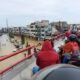 WARGA beramai-ramai melihat kondisi banjir dari atas Flyover Pulo Brayan pada Sabtu (19/11). Waspada/Ist
