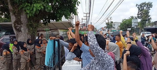 Ratusan masyarakat Desa Sisoma menggelar aksi unjuk rasa dihalaman Kejari Palas, meminta Kades Sisoma diperiksa dan ditangkap terkait dugaan tindak pidana korupsi dana desa 2016-2021. Senin (26/12) (Waspada/Muhammad Satio)