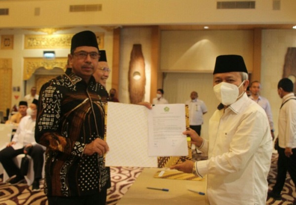Kakanwil Kemenag Aceh Dr Iqbal (kiri) memperlihatkan dokumen perjanjian kinerja anggaran tahun 2023 usai penandatangan di hotel Holiday Inn Resort, Denpasar, Bali, Selasa (13/12/22). (Waspada/Ist)