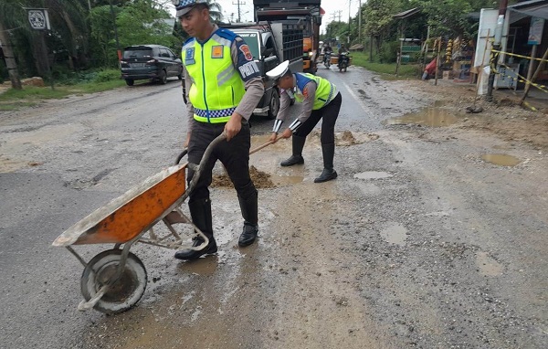POLISI TUTUPI JALAN RUSAK: Personel Satlantas menutupi badan jalan yang rusak agar tidak terjadi kecelakaan di Jalinsum Banda Aceh – Medan, di Gampong Alue Bu Jalan, Peureulak Barat, Aceh Timur, Rabu (14/12). Waspada/M Ishak