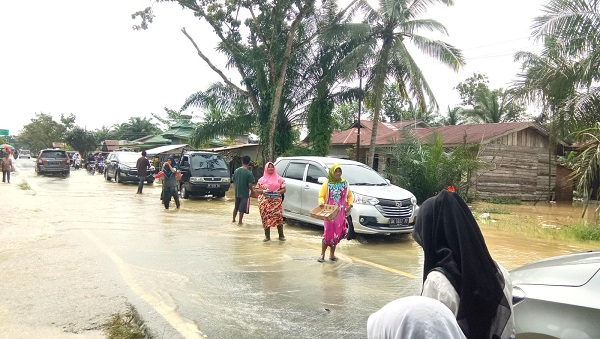 ARUS banjir menyeberangi ruas jalan nasional di Kel. Kampung Lama - Kel. Bukit Kubu, Kec. Besitang. Waspada/Asrirrais