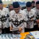 BUPATI Deliserdang H.Ashari Tambunan bersama Wakil Bupati HMA Yusuf Siregar melihat salah satu buku bacaan ketika mengunjungi stand pameran Dinas Pendidikan Deliserdang pada puncak HGN dan HUT ke-77 PGRI Tahun 2022 di GOR Lubukpakam, Kamis (15/12) sore.- (Waspada/Khairul K Siregar/B)