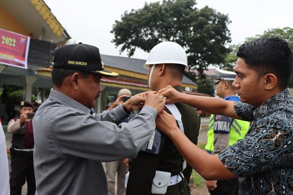 Wali Kota Binjai Drs H Amir Hamzah M AP melakukan pemasangan pita kepada anggota PM yang mengikuti apel pasukan lilin toba 2022. (Waspada/Ist).