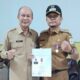 Syariful Alam, Datok Kampung Kesehatan, Kec Karang Baru foto bersama Bupati Aceh Tamiang seusai menerima piagam penghargaan dari Desa Mandiri dari Menteri Desa RI, Senin (26/12) di kantor Camat Karang Baru. (Waspada/Yusri).