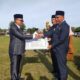 Pj Bupati Abdya Darmansah, menyerahkan hibah aset tanah milik Pemkab, juga bangunan kepada Kakankemenag Abdya Salman Alfarisi, dalam peringatan HAB ke 77 di lapangan Pantai Perak Susoh, Selasa (3/1/2023). Waspada/Syafrizal