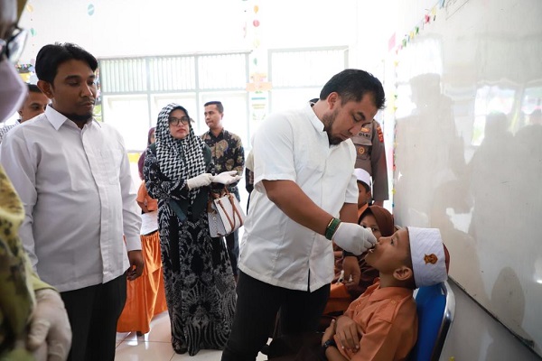 Penjabat Bupati Aceh Besar, Muhammad Iswanto, S.STP MM secara simbolis melakukan vaksinasi polio tetes di SDN Pertiwi Lamgarot, Gampong Siron, Kecamatan Ingin Jaya, Jumat (13/1) pagi. (Waspada/Zafrullah)