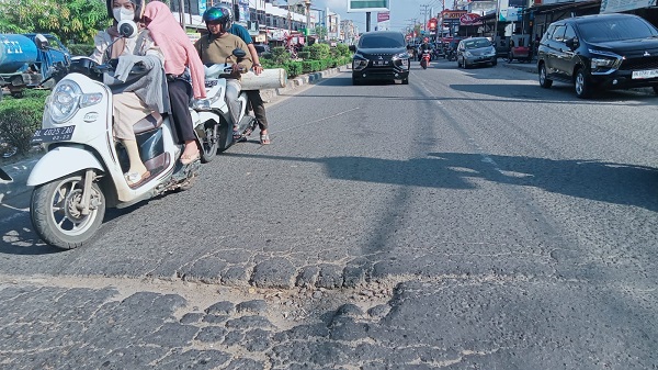 Sepanjang jalan nasional Banda Aceh – Medan yang melintasi wilayah Kota Lhokseumawe, tepatnya di Keude Cunda, Selasa (3/1), kini terbiar rusak dan banyak lubang maut yang mengancam keselamatan orang yang melintas. Waspada/Zainuddin Abdullah