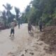 Bersama masyarakat, Babinkamtibmas Polsek Muarasipongi Bripka S.P. Nainggolan bersama Babinsa Koramil 15 Muarasipongi Kopda Mulyadi membersihkan tanah longsor dan banjir menutupi jalan umum. Waspada.id/dok