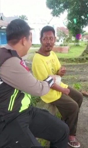 Foto Bripka Ami Al Hasir Harahap personel Satlantas Polres Simalungun saat bersama ODGJ di jalan Siantar - Medan, dipetik dari instagram akun @Kapolres_Simalungun.(Waspada/ist).