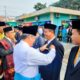 WAKIL Bupati Deliserdang HMA Yusuf Siregar didampingi Kakan Kemenag Deliserdang H.Abdul Haris Harahap menyematkan penghargaan Satyalancana Karya Satya XX Tahun kepada Pengawas Madya Pendidikan Agama Islam Parulian Daulay pada peringatan Hari Amal Bhakti ke 77 Tahun 2023 Kabupaten Deliserdang di halaman samping Kantor Kemenag Deliserdang, Selasa (3/1).- (Waspada/Khairul K Siregar/B)