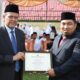 Pj Bupati Aceh, Besar Muhammad Iswanto, SSTP MM, saat menerima penghargaan dari KemenagRI melalui Dirjen Pendidikan Islam, Muhammad Ali Ramdhani. (Waspada/Ist)