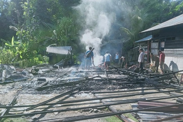Warga terlihat masih berusaha menyirami puing-puing sisa kebakaran, setelah api besar berhasil dipadamkan, dan rumah musnah terbakar. WASPADA/Ariefh