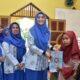 KETUA DPD Muslimat Al Ittihadiyah Kabupaten Batubara Ny. Hj. Maya Indriasari Zahir, SE. saat menyerahkan bantuan Alquran dan honor guru mengaji Taman Bacaan Al-Qur'an Al Muklhisin Dusun Jambu, Lauttador. Waspada/Iwan Has
