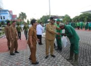Penjabat Wali Kota Lhokseumawe, Dr Drs Imran M.Si secara simbolis menyerahkan 350 paket bantuan beras dan sertifikat penghargaan kepada pekerja kebersihan Dinas Lingkungan Hidup dan Kebersihan dihalaman Kantor Walikota setempat, Senin (13/3). Waspada/Zainuddin Abdullah