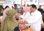 Wali Kota Padangsidempuan Irsan Efendi Nasution (kanan) melayani salah seorang pembeli di Gerakan Pasar Murah yang dilaksanakan BI Sibolga bekerjasama dengan Pemko Padangsidempuan.Waspada/ist.