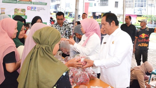 Wali Kota Padangsidempuan Irsan Efendi Nasution (kanan) melayani salah seorang pembeli di Gerakan Pasar Murah yang dilaksanakan BI Sibolga bekerjasama dengan Pemko Padangsidempuan.Waspada/ist.