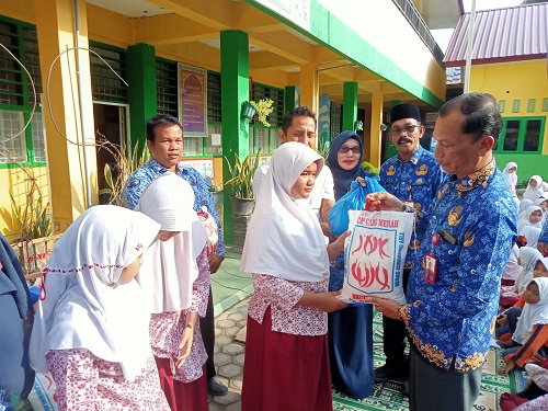 Kepala Dinas Pendidikan dan Kebudayaan Pemko Lhokseumawe, A.Haris, S.Sos, M.Si, di dampingi Sekdis Ikhwansyah dan Kepsek SDN-4 Banda Sakti, menyerahkan santunan anak yatim di SD Negeri 4 Banda Sakti, Lhokseumawe, Jumat (17/3). Waspada/Ist
