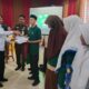 Staf Ahli Bidang Perekonomian, Keuangan dan Pembangunan, Ir Makmun MT, menyerahkan buku sadar hukum kepada siswa saat mengikuti penyuluhan hukum Program Jaksa Masuk Sekolah (JMS) di Gedung Dekranasda, Rabu (8/3). (Waspada/Zafrullah)