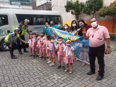 PERSONEL Sat Lantas Polrestabes Medan foto bersama dengan murid-murid TK Swasta Bina Insan Mandiri Jl. Bambu II Kelurahan Gaharu Kecamatan Medan Timur, Kamis (9/3) usai melakukan sosialisasi rambu lalulintas. Waspada/Ist