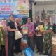 Kepala Diskopukmdag Aceh Besar, Ir. Darmansyah, ST, MSi, menyerahkan paket pasar murah secara simbolis kepada seorang warga pada operasi pasar khusus dalam rangka penanganan inflasi dan stabilisasi harga bahan pokok saat Hari Besar Keagamaan Nasional (HBKN) di Pasar Lamtamot, Kecamatan Lembah Seulawah, Kabupaten Aceh Besar, Kamis (13/4). (Waspada/Ist)