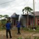 PETUGAS pemadam saat melakukan pemadaman rumah yang terbakar. (Waspada/Ist)