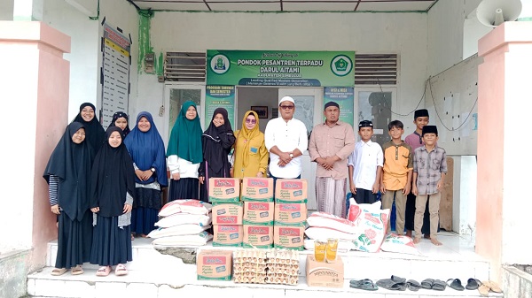 Ustadz Ifdhal Ma'asy menerima bantuan dari Perwakilan PT ALS dengan didampingi beberapa Santri Darul Aitami Desa Linggi, Simeulue. Rabu (12/4). Waspada/Ist.
